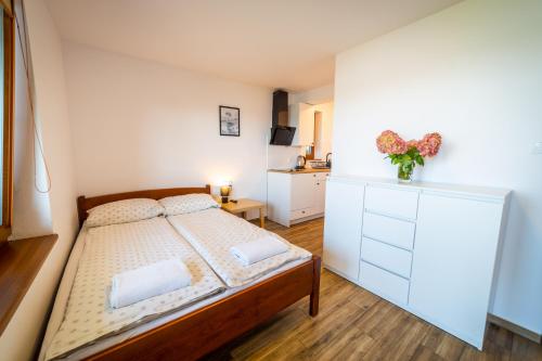 a small bedroom with a bed and a dresser at Willa Tałty in Mikołajki