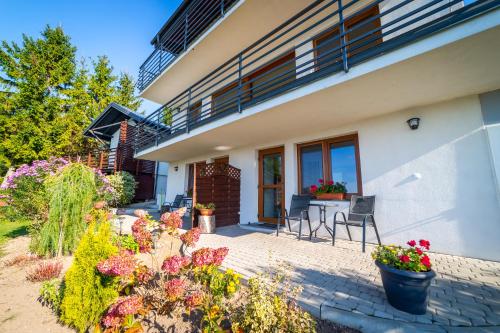 a house with a patio with flowers and plants at Willa Tałty in Mikołajki