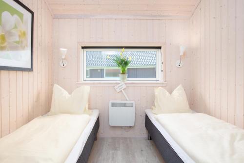 - 2 lits dans une petite chambre avec fenêtre dans l'établissement Resort 2 Sea Lodge C 112, à Großenbrode