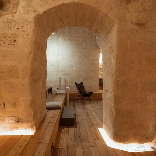 a room with a stone wall and an archway at Piano Piano - Rooms in Matera
