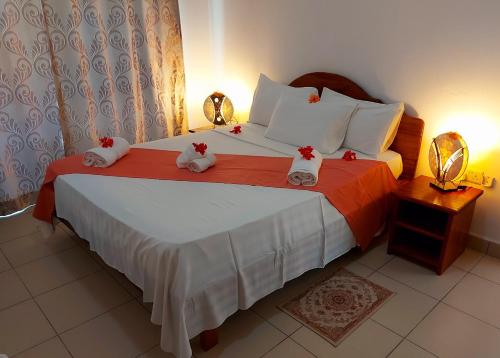 a bedroom with a bed with two stuffed animals on it at Hostellerie La Digue in La Digue