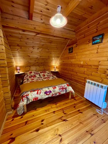 une chambre avec un lit dans une cabane en rondins dans l'établissement Chalet Des Feignes, à La Bresse