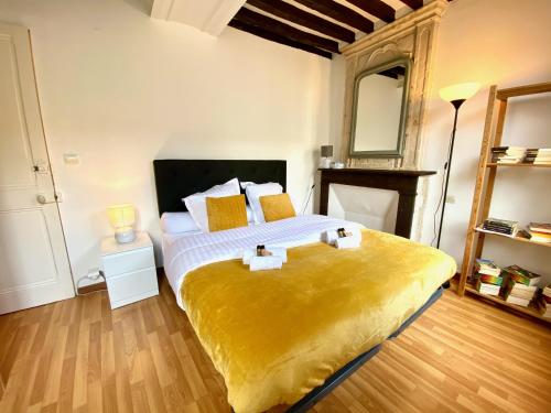 1 dormitorio con 1 cama grande con manta amarilla en Nashira YourHostHelper, en Caen