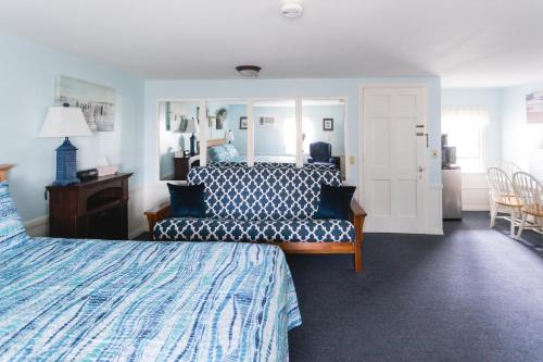 a bedroom with a bed and a couch and a mirror at A Beach Breeze Inn in West Harwich