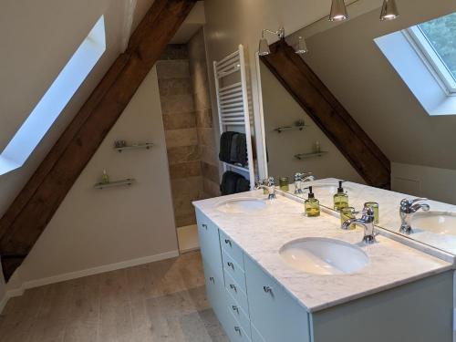 a bathroom with two sinks and a large mirror at Château de Brissac in Brissac-Quincé