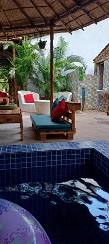 a pool with a bed and a table and chairs at Red Monkeys Hostel in Arambol