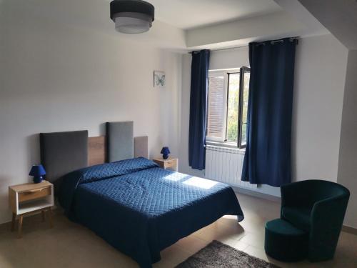 1 dormitorio con 1 cama azul y 1 silla verde en Montesarchiorooms en Montesarchio