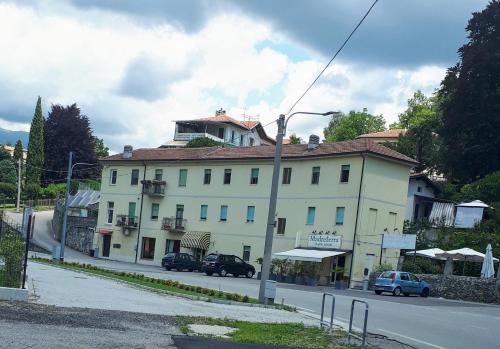 a large white building on the side of a street at ...per il Sirio in Ivrea