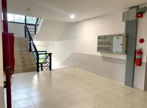 an empty room with stairs and a fire extinguisher at Baan Chomphu Pakchong in Ban Nong Sarai (1)