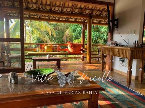 a living room with a table and a piano at Villa Nicolle - Bahia - Praia do Espelho in Praia do Espelho