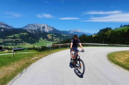 a man riding a bike down a road at Alpenchalet im Steirischen Salzkammergut in Tauplitz