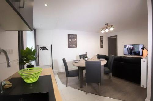 une salle à manger et un salon avec une table et des chaises dans l'établissement L'ESCAPADE PROCHE CENTRE PARKING Home-One, à Dole