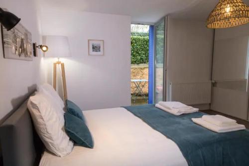 une chambre avec un lit avec une couverture bleue dans l'établissement L'ESCAPADE PROCHE CENTRE PARKING Home-One, à Dole