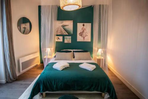 - une chambre avec un lit vert et 2 serviettes dans l'établissement LE CANAL PARKING GRATUIT Home-One, à Dole