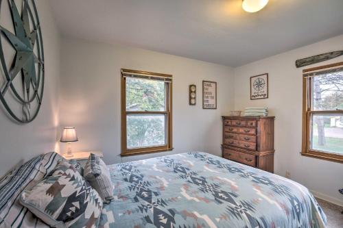 BirchwoodにあるBirchwood Cottage with Red Cedar Lake Access!のベッドルーム1室(ベッド1台、ドレッサー、窓2つ付)