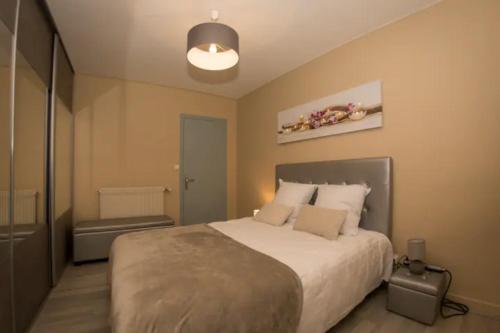 une chambre avec un grand lit dans une pièce dans l'établissement LA COMMANDERIE JARDIN PARKING Home-One, à Dole