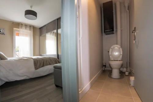 une salle de bain avec un lit et des toilettes dans une chambre dans l'établissement LA COMMANDERIE JARDIN PARKING Home-One, à Dole