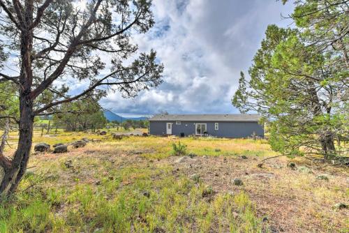 a barn in the middle of a field with trees at Cedaredge Hideaway with Grill and Mountain Views! in Cedaredge