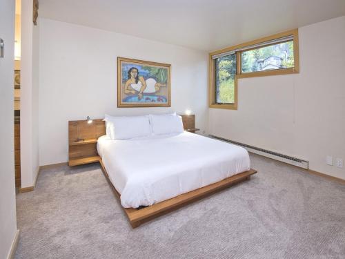 sypialnia z dużym białym łóżkiem i 2 oknami w obiekcie Millrace 7-b w mieście Vail