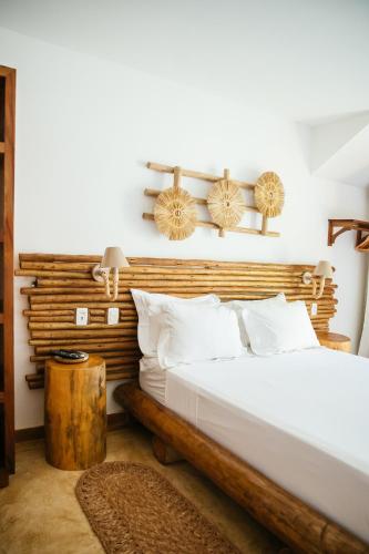 a bedroom with a bed and a wooden headboard at VillaMag in Jericoacoara