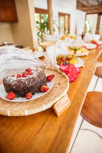 a long table with a cake with strawberries on it at VillaMag in Jericoacoara