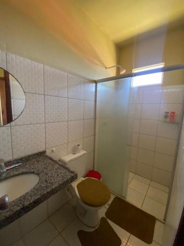 a bathroom with a toilet and a sink and a shower at Flat Praia da Taíba - com vista Mar in Taíba