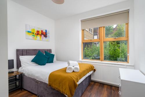 a bedroom with a bed and a window at Stylish Central Watford 2 Bedroom and Sofa Bed Apartment with Free Parking in Watford