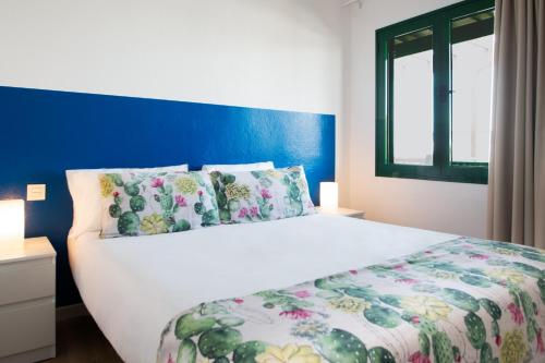 プラヤ・ブランカにあるBlancazul Tegalaのベッドルーム1室(青い壁の白いベッド1台付)