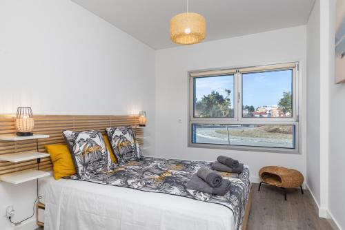 a bedroom with a bed and a window at One River Seixal in Seixal