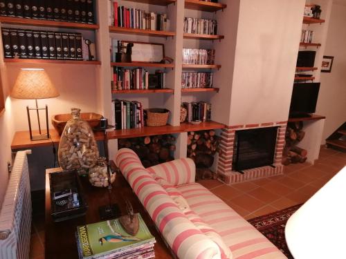sala de estar con sofá y chimenea en Casa Rural el Pajar de Tenzuela, en Pelayos del Arroyo