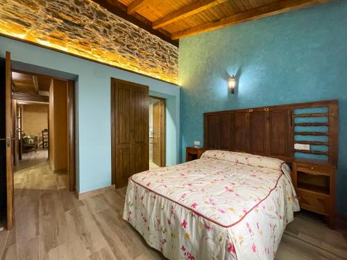 1 dormitorio con cama y pared azul en Recuerdos de Monfragüe, en Malpartida de Plasencia