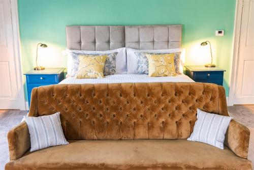 a large bed with a couch in a bedroom at The Boarding House in Halesworth