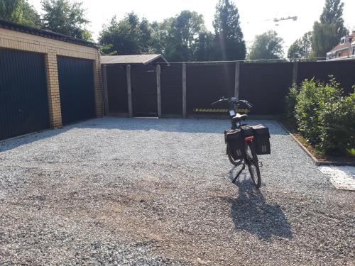 a bike parked in a parking lot next to a fence at Vertentenhuis in Hamme