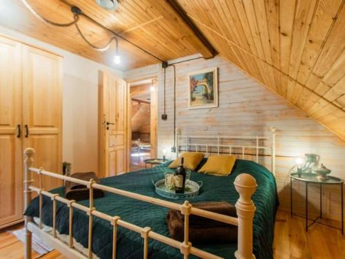 a bedroom with a bed in a room with wooden ceilings at Domek Serce Lasu in Hutki