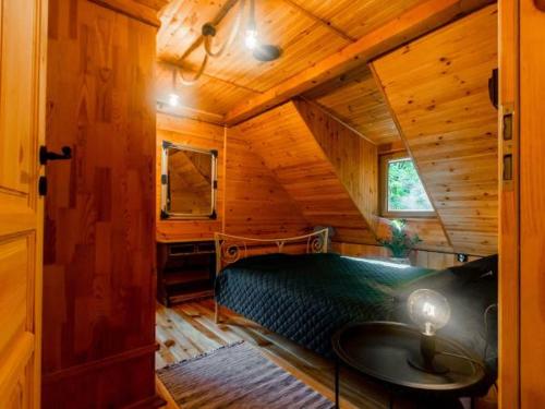 a bedroom with a bed in a wooden cabin at Domek Serce Lasu in Hutki