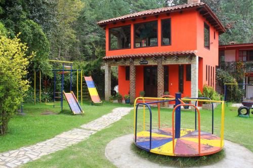 um parque infantil em frente a um edifício com uma laranja em Hotel Campestre Las Flores em San Cristóbal de Las Casas