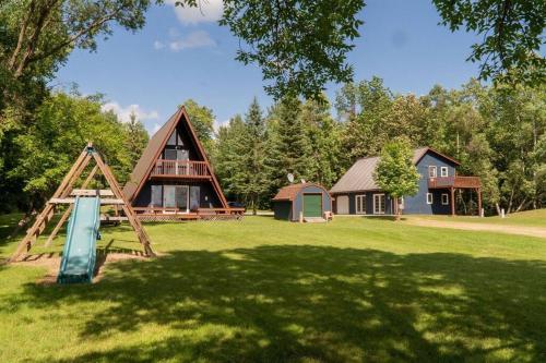 a park with a playground and a house at Aframe on Bass Lake in Grand Rapids