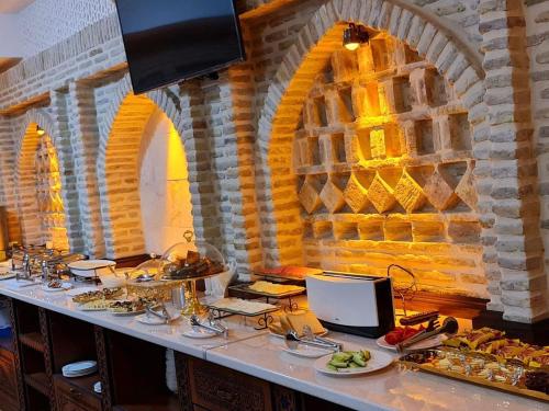 een buffet lijn met eten op een tafel in een gebouw bij Royal Bukhara hotel in Bukhara