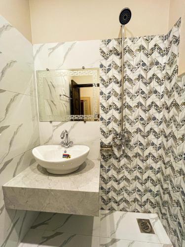 a bathroom with a sink and a mirror at Horizon Hotel in Lahore