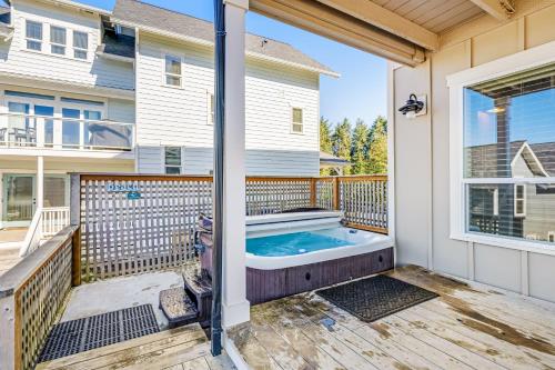 a hot tub on a deck next to a house at Driftwood Star in Lincoln City