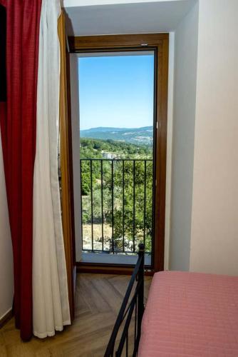 a bedroom with a window with a view of a balcony at IL MASCHERONE in Sepino