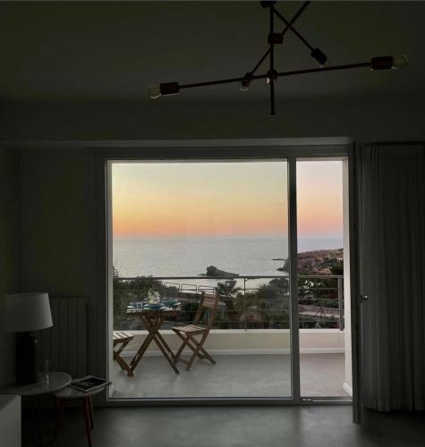 a room with a large sliding glass door with a view of the ocean at Cocciu d’amuri in Terrasini