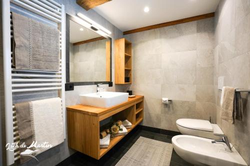 ein Bad mit einem Waschbecken und einem WC in der Unterkunft Lüch de Martin in Wengen