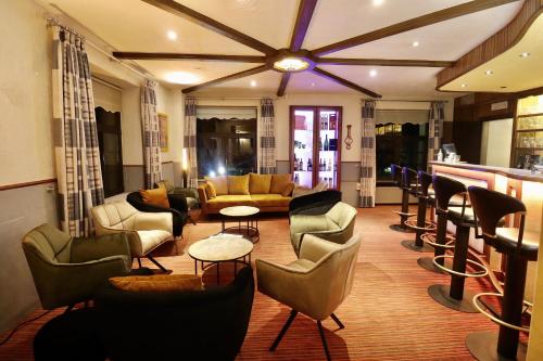 a lobby with couches and chairs and a bar at Hotel Val de l'Our in Burg-Reuland