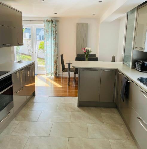 a kitchen with a counter and a dining room at Sunny Corner, Padstow. Spacious 3 bedrooms, 2.5 bathrooms, parking, garden. in Padstow