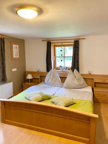 a bedroom with a large bed with a window at Waldruhe Appartements in Sankt Jakob in Defereggen