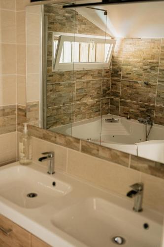 une salle de bain avec un lavabo et une baignoire dans l'établissement Maison Kyma, à Gujan-Mestras