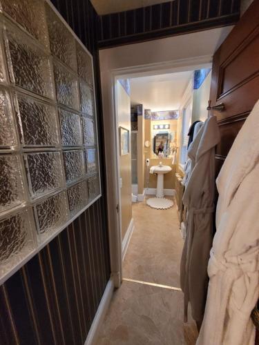a hallway with a room with a toilet and a sink at Ruby Manor Bed & Breakfast in Gananoque