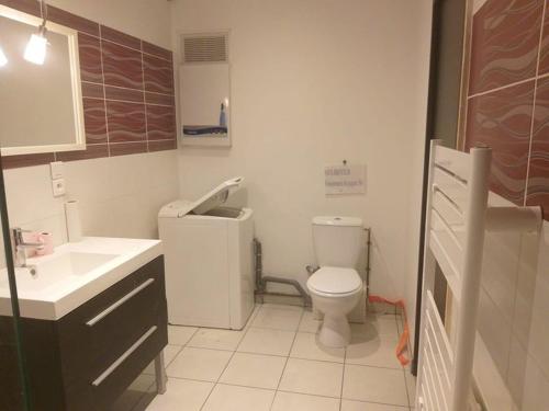 een badkamer met een wit toilet en een wastafel bij Au Paradis des Grillons in Espinasses