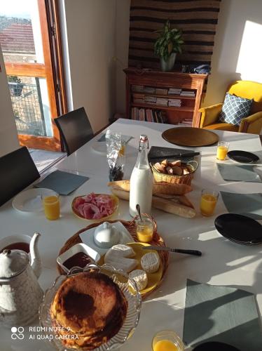 einen Tisch mit einem Teller Essen und einer Flasche Milch in der Unterkunft la ferme de fenivou in Boulieu-lès-Annonay